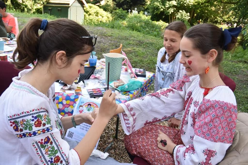 Două fete în ie lucrează la un atelier creativ în aer liber